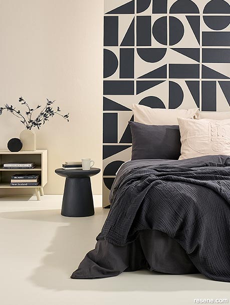 A bedroom with a painted geometric wall design