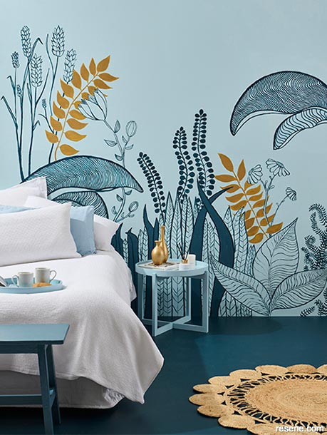 A blue and gold tropical mural features in this bedroom